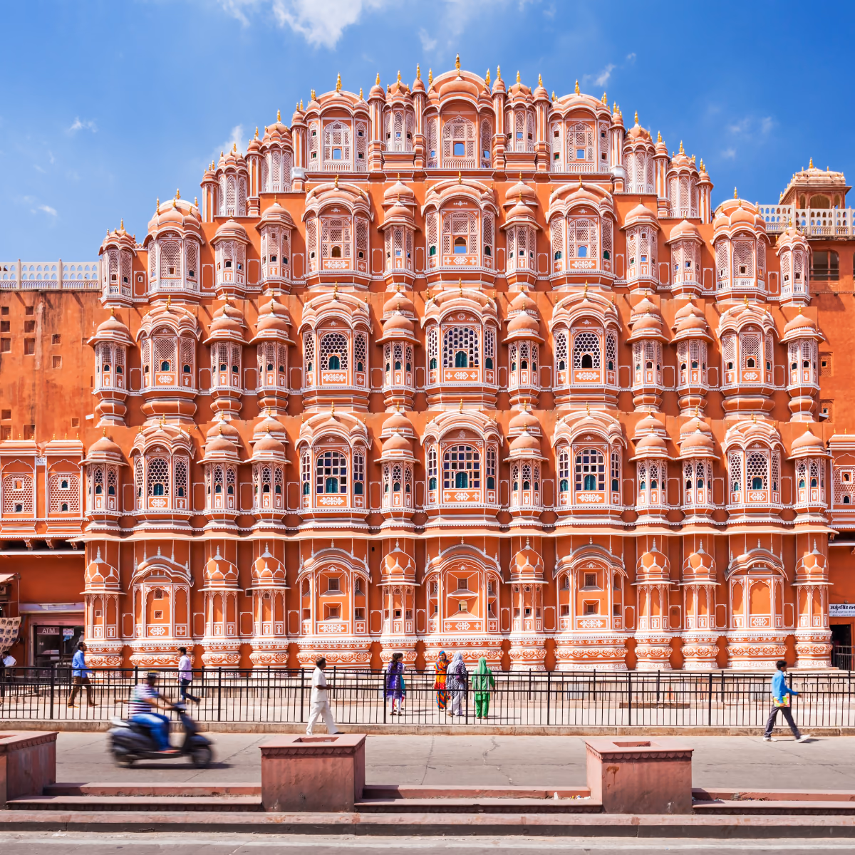 Scena di viaggio a Hawa Mahal's rosa facade sopra una lively Jaipur street., tra paesaggio locale e atmosfera del luogo.