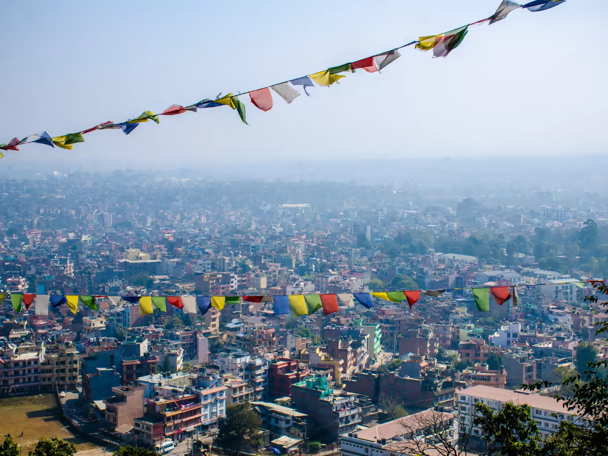 A quiet Kathmandu courtyard with prayer flags in soft morning light.