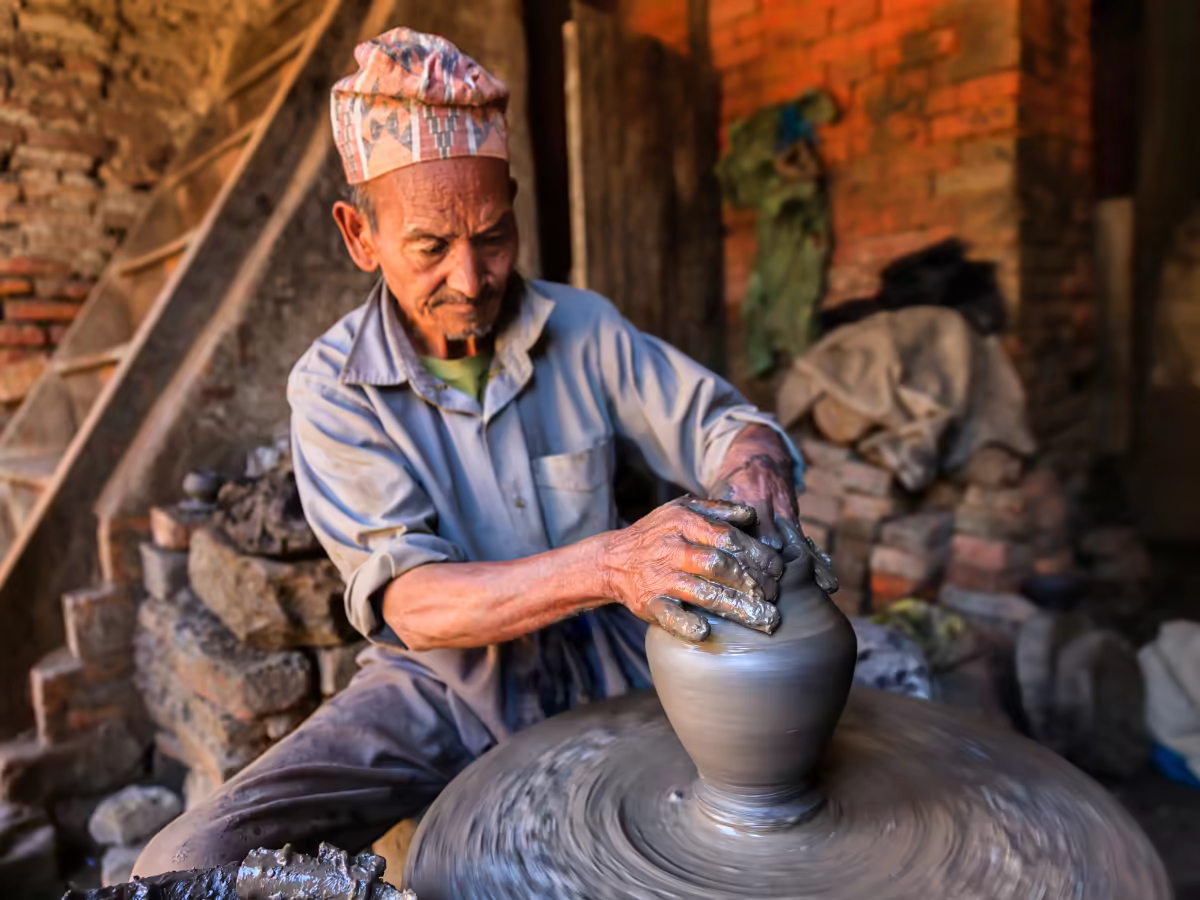 A potter shaping terracotta in Bhaktapur's brick Durbar Square.