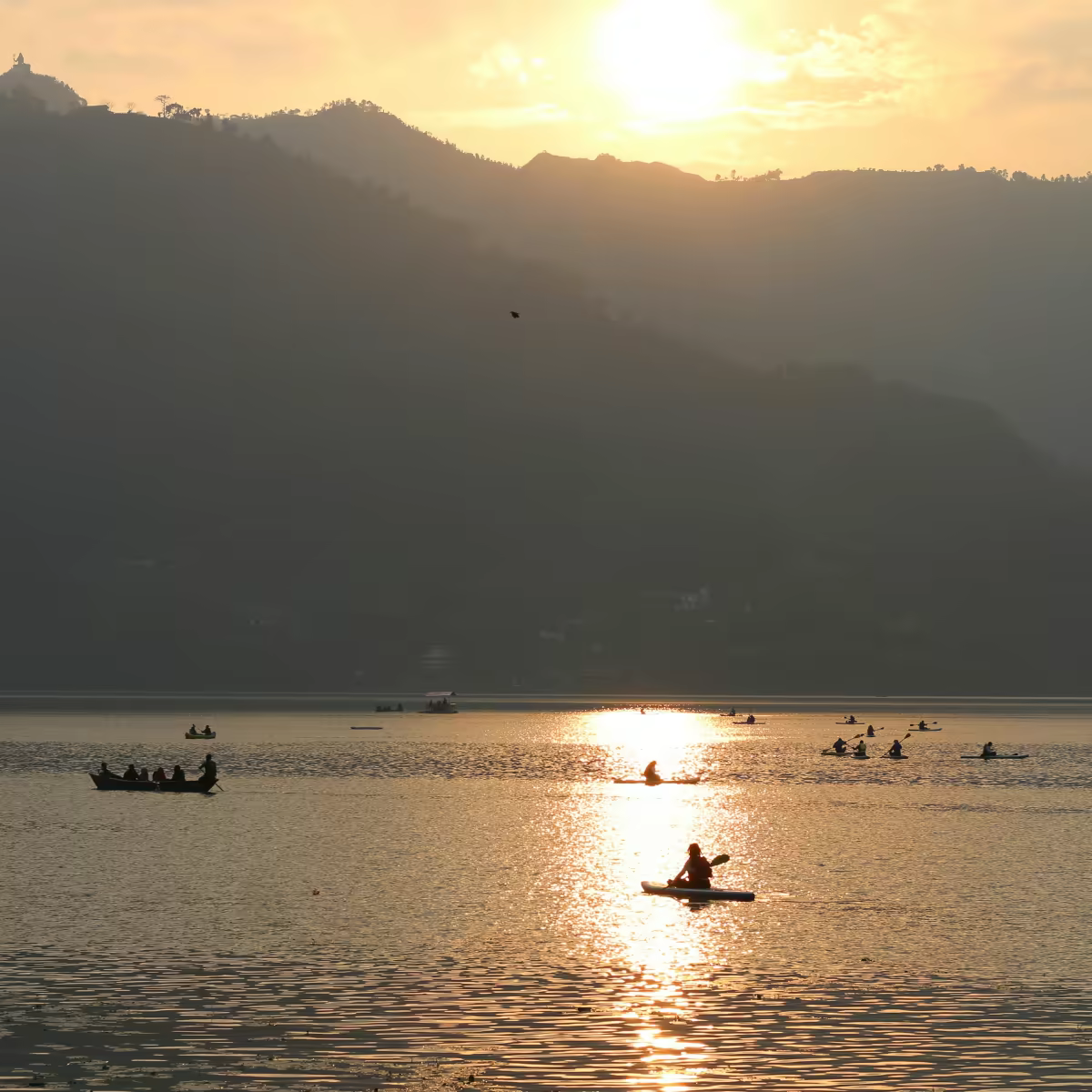 A wooden boat and mountain reflection on Phewa Lake in Pokhara.