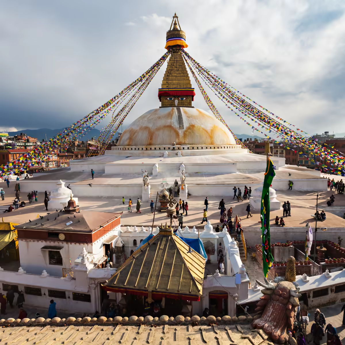 Pilgrims circling Boudhanath Stupa beneath prayer flags in Kathmandu.