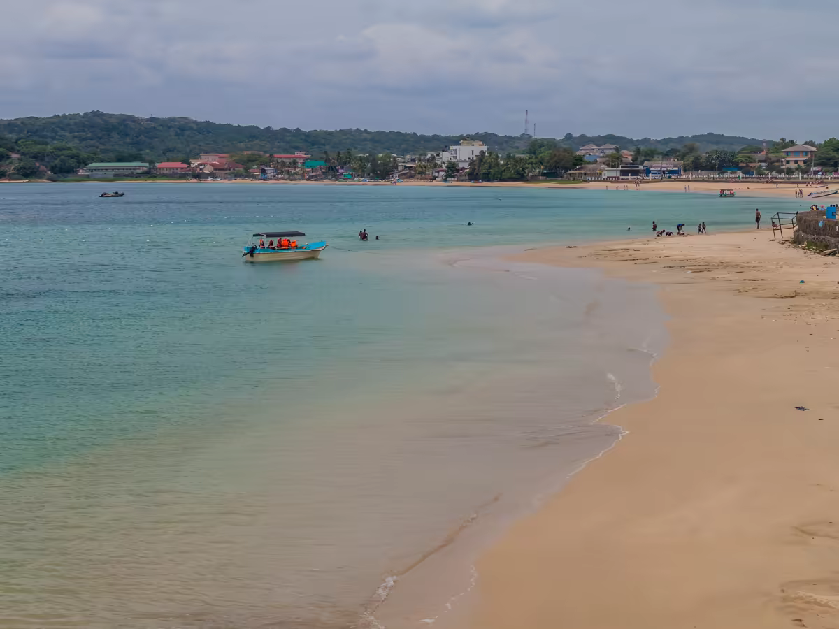 A fishing boat crossing Trincomalee's clear blue bay.