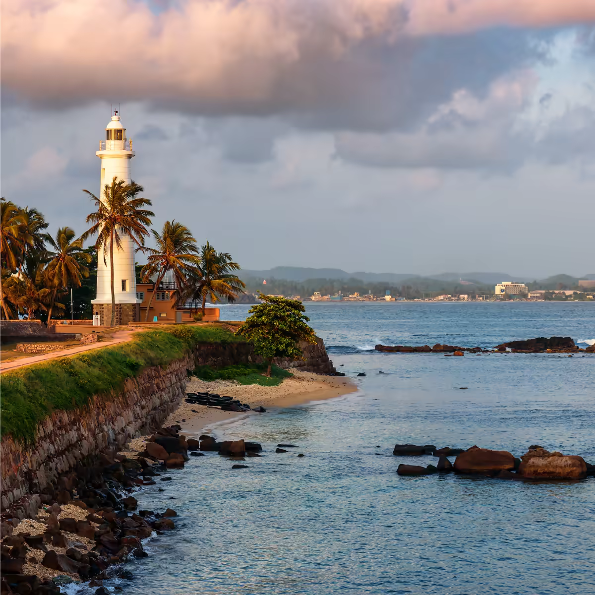 A cyclist beside Galle Fort's ramparts above the Indian Ocean.